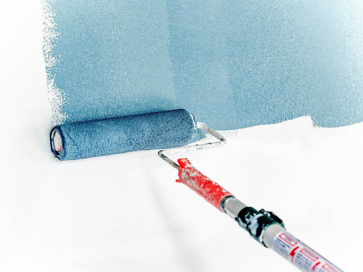 Rodillo de pintura sobre una pared recién pintada