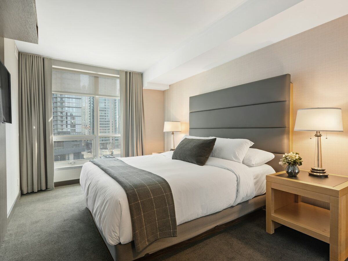 Habitación de hotel con cama de matrimonio y ropa de cama blanca